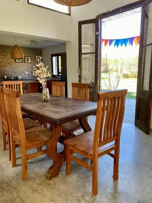 a dining room with a wooden table and chairs at Casa de Las Brujas Traslasierra in Los Molles