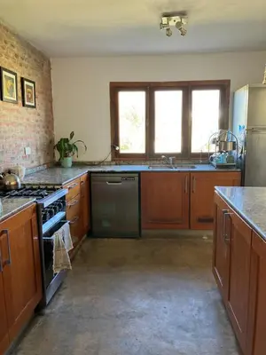 a kitchen with wooden cabinets and a stove top oven at Casa de Las Brujas Traslasierra in Los Molles
