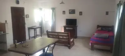 a living room with a table and a bed at Caminito1 in Villa Anizacate