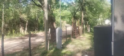 a fence in front of a road with trees at Caminito1 in Villa Anizacate