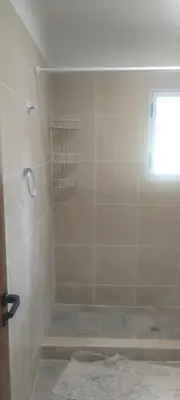 a bathroom with a shower with a tub and a window at Caminito1 in Villa Anizacate