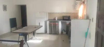 a small kitchen with a table and a refrigerator at Caminito1 in Villa Anizacate