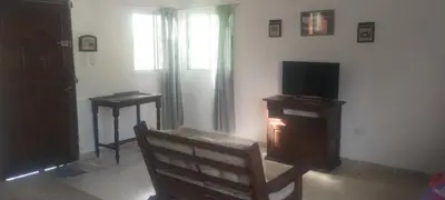 a living room with a tv and a wooden chair at Caminito1 in Villa Anizacate