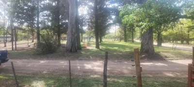 a gate in a park with trees and a playground at Caminito1 in Villa Anizacate