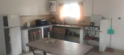 a small kitchen with a table and a refrigerator at Caminito1 in Villa Anizacate