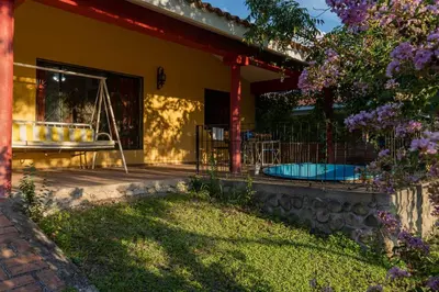 a house with a porch and a swimming pool at Alojamiento Arroyo de los Patos in Arroyo de Los Patos