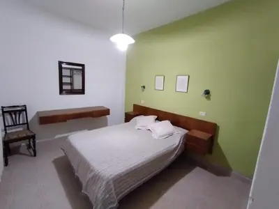 a bedroom with a bed and a chair at Alojamiento Arroyo de los Patos in Arroyo de Los Patos