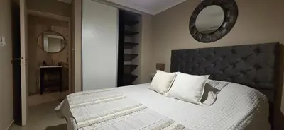 a bedroom with a white bed with a large mirror at Departamento a estrenar deluxe in Cordoba