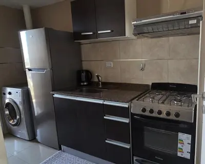 a kitchen with a stove and a sink and a refrigerator at Departamento a estrenar deluxe in Cordoba