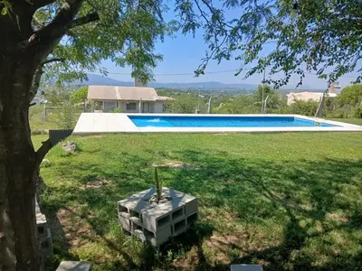 a yard with a swimming pool and a tree at cabaña Mirador in Bialet Massé
