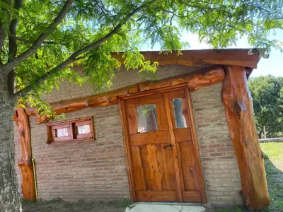 a small brick building with a large wooden door at cabaña Mirador in Bialet Massé