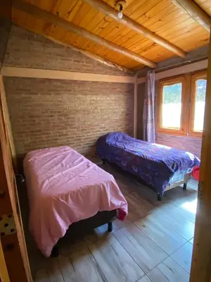 a bedroom with two beds in a log cabin at cabaña Mirador in Bialet Massé