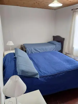 a bedroom with two beds with blue sheets and a lamp at Terrazas del Kempes- Sanatorio Allende Cerro in Cordoba