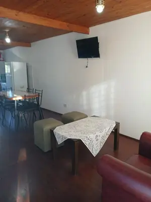 a living room with a table and a tv on a wall at Terrazas del Kempes- Sanatorio Allende Cerro in Cordoba
