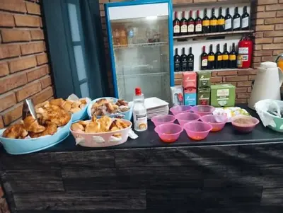 a table with bowls of food and bottles of wine at New POSADA SOL in Villa Carlos Paz
