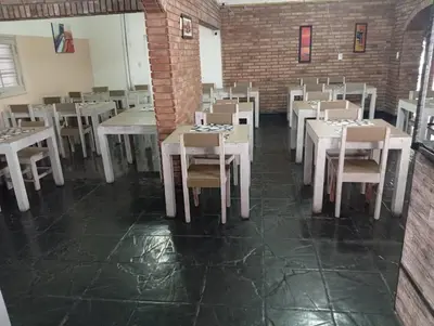 a dining room with white tables and chairs at New POSADA SOL in Villa Carlos Paz