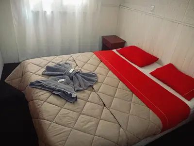 a bedroom with a bed with a red and white comforter at New POSADA SOL in Villa Carlos Paz