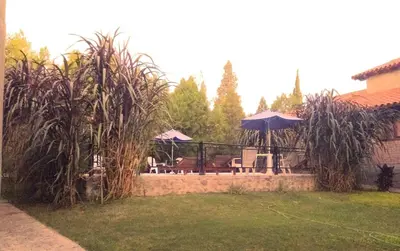 a backyard with a patio with a table and an umbrella at Cabaña en el centro La Casona in Mina Clavero