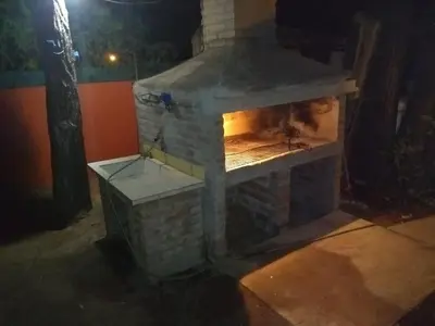an outdoor brick fireplace at night at Cabaña en el centro La Casona in Mina Clavero