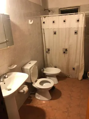 a bathroom with a white toilet and a sink at Cabaña en el centro La Casona in Mina Clavero