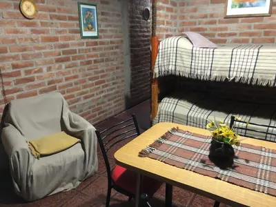 a room with a table and a chair and a bed at Cabaña en el centro La Casona in Mina Clavero