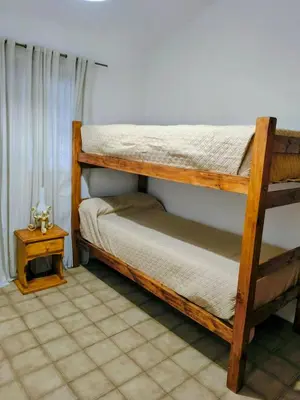 a bedroom with two bunk beds and a table at Fidelita in Villa Carlos Paz