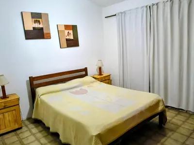 a bedroom with a bed and a large window at Fidelita in Villa Carlos Paz