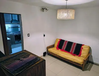 a living room with a couch and a mirror at Fidelita in Villa Carlos Paz