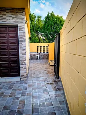 a garage with a brown door and a brick wall at Fidelita in Villa Carlos Paz