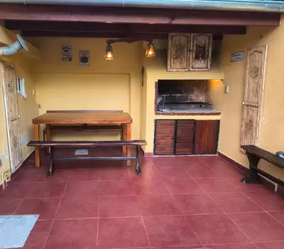 a kitchen with a table and a bench in a room at Fidelita in Villa Carlos Paz