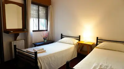 a room with two beds and a mirror and a window at Hotel Maspalomas in Villa Carlos Paz