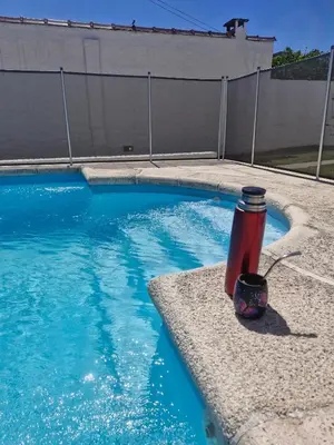 a red fire hydrant sitting next to a swimming pool at Hotel Maspalomas in Villa Carlos Paz