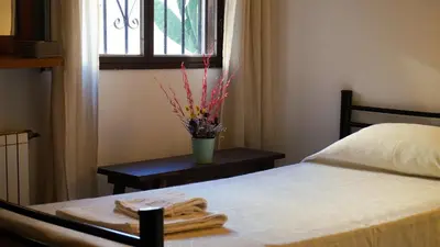 a bedroom with a bed and a table with a window at Hotel Maspalomas in Villa Carlos Paz