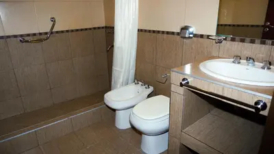 a bathroom with a toilet and a sink at Hotel Maspalomas in Villa Carlos Paz