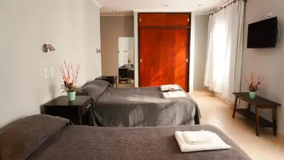 a hotel room with two beds and a television at Hotel Maspalomas in Villa Carlos Paz