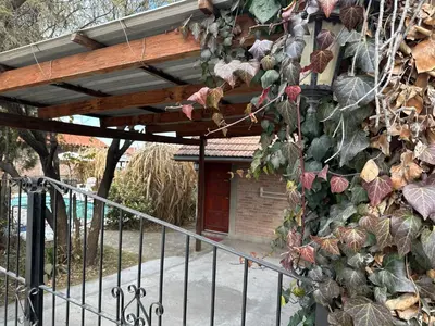 a building with a bunch of plants on the side of it at Cabaña La Casona en el centro in Mina Clavero