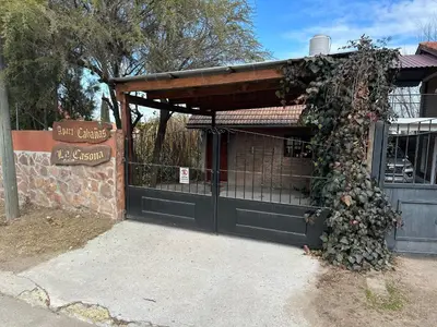 a gate to a building with a bunch of flowers at Cabaña La Casona en el centro in Mina Clavero