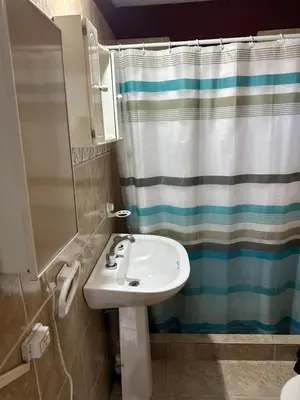 a bathroom with a sink and a shower curtain at Cabaña La Casona en el centro in Mina Clavero