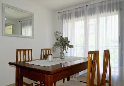 a dining room table with a vase of flowers on it at Departamento Pilay Futura Seguridad las 24 horas in Cordoba
