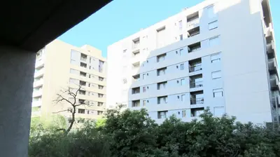 a white apartment building with trees in front of it at Departamento Pilay Futura Seguridad las 24 horas in Cordoba