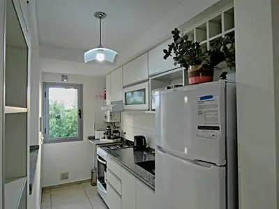 a kitchen with white cabinets and a refrigerator at Departamento Pilay Futura Seguridad las 24 horas in Cordoba