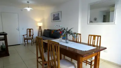 a living room with a wooden table and chairs at Departamento Pilay Futura Seguridad las 24 horas in Cordoba