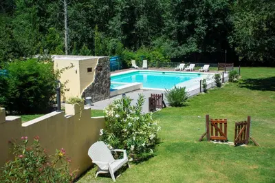 a swimming pool in a yard with a white chair at Panacea Hotel in Villa General Belgrano
