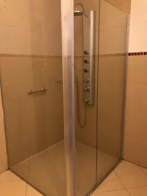 a shower with a glass door in a bathroom at Panacea Hotel in Villa General Belgrano