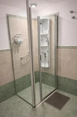 a shower with a glass door in a bathroom at Panacea Hotel in Villa General Belgrano