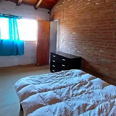 a bedroom with a bed and a brick wall at La Serranita in Panaholma