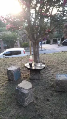 a picnic table in front of a tree with rocks at Cazona Villa Carmen in Villa Carlos Paz