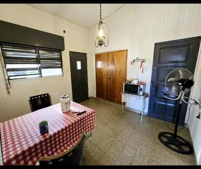 a room with a table and a blue door and a microwave at Cazona Villa Carmen in Villa Carlos Paz