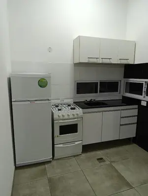 a kitchen with a stove and a refrigerator at Sinaí Apart in Santa Rosa de Calamuchita
