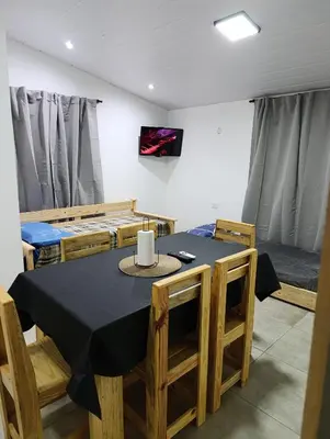 a dining room with a black table and chairs at Sinaí Apart in Santa Rosa de Calamuchita